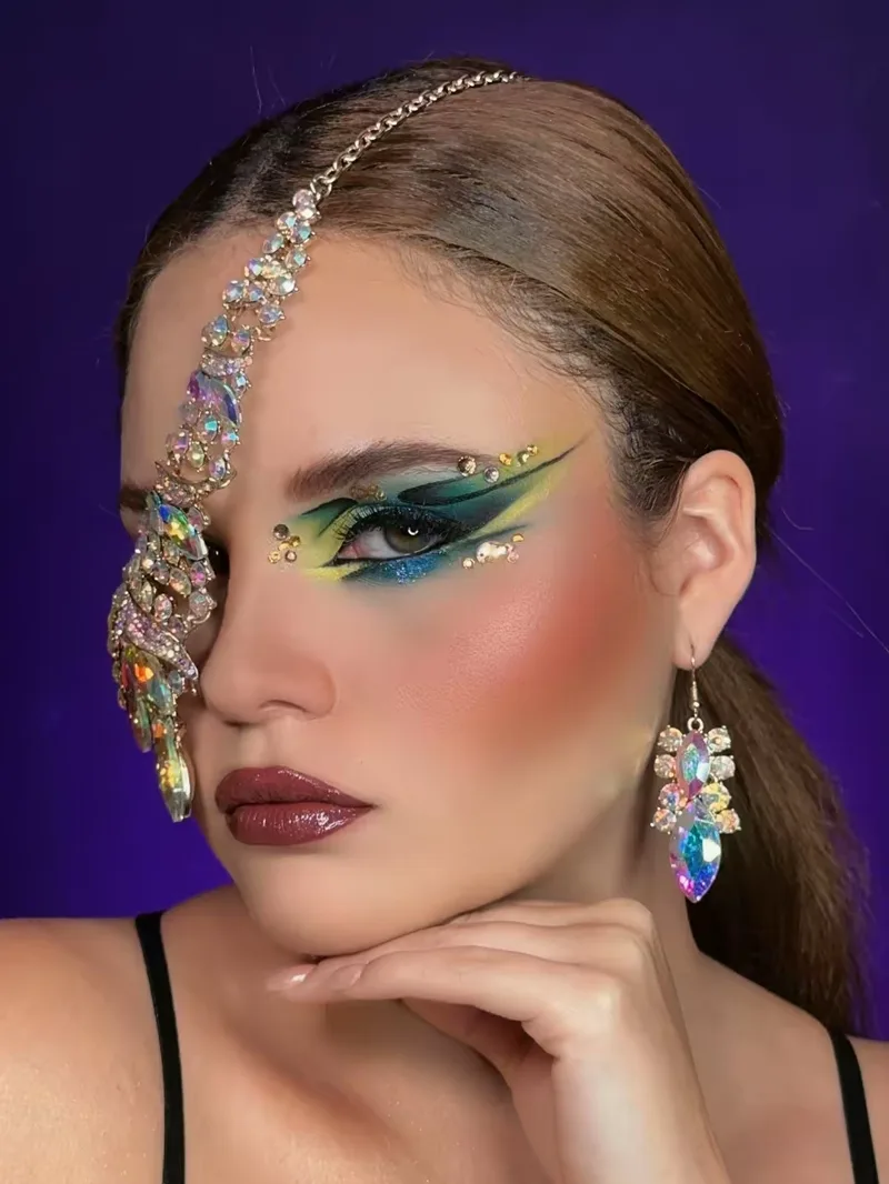 Trabajo editorial con pedrería, delineado verde y labio vino